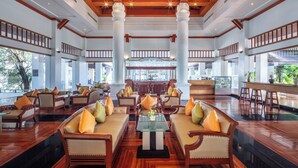 A spacious lobby with high ceilings, wooden beams, and a central bar area. - Tawa Ravadee Resort, WorldHotels Distinctive (Si Maha Phot)