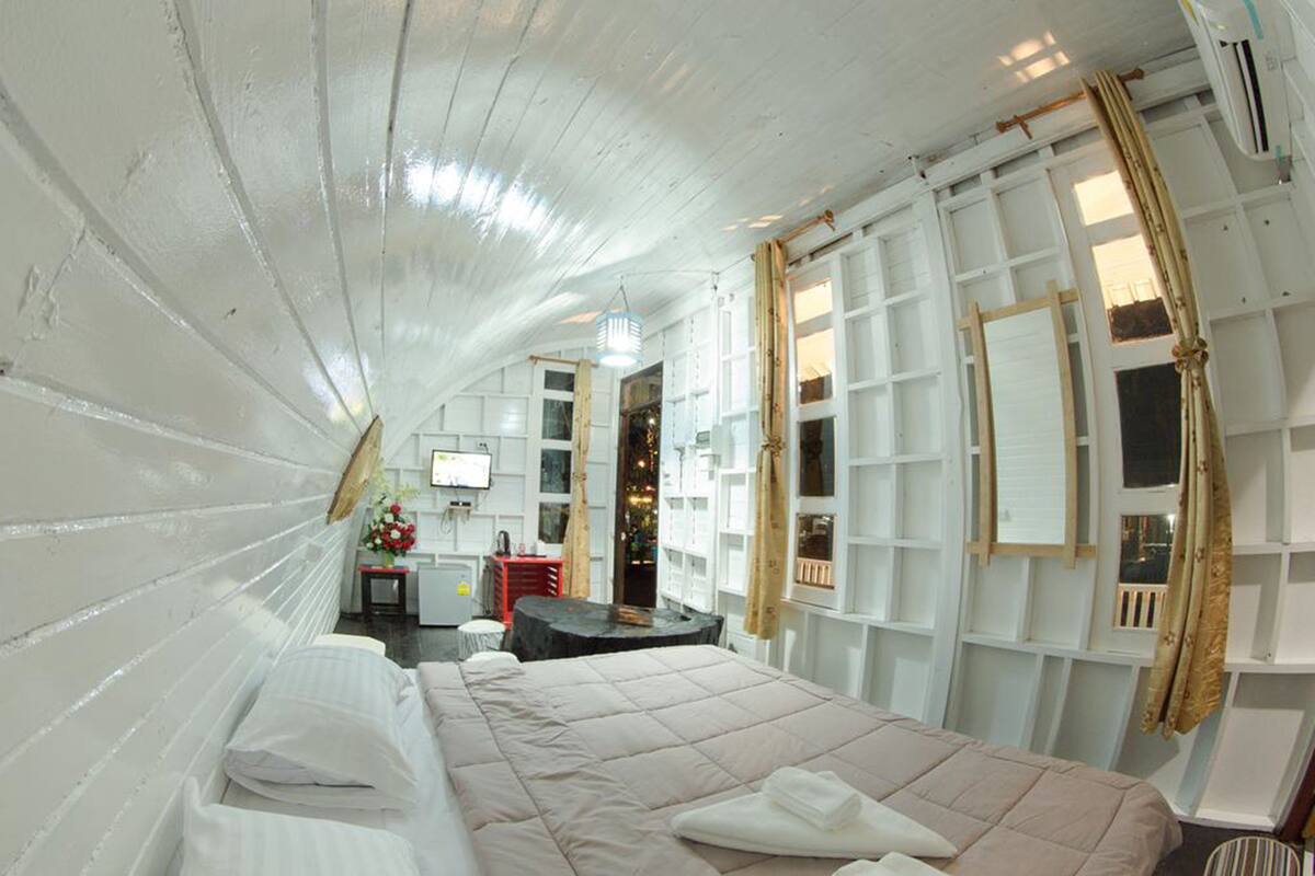 Ein Zimmer mit einem Bett, einem Schreibtisch und einem Fernseher.