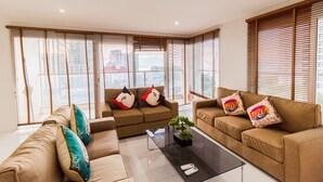 A modern living room with two sofas, a coffee table, and a small plant. - The Place Pratumnak by PSR ASIA (Pattaya)