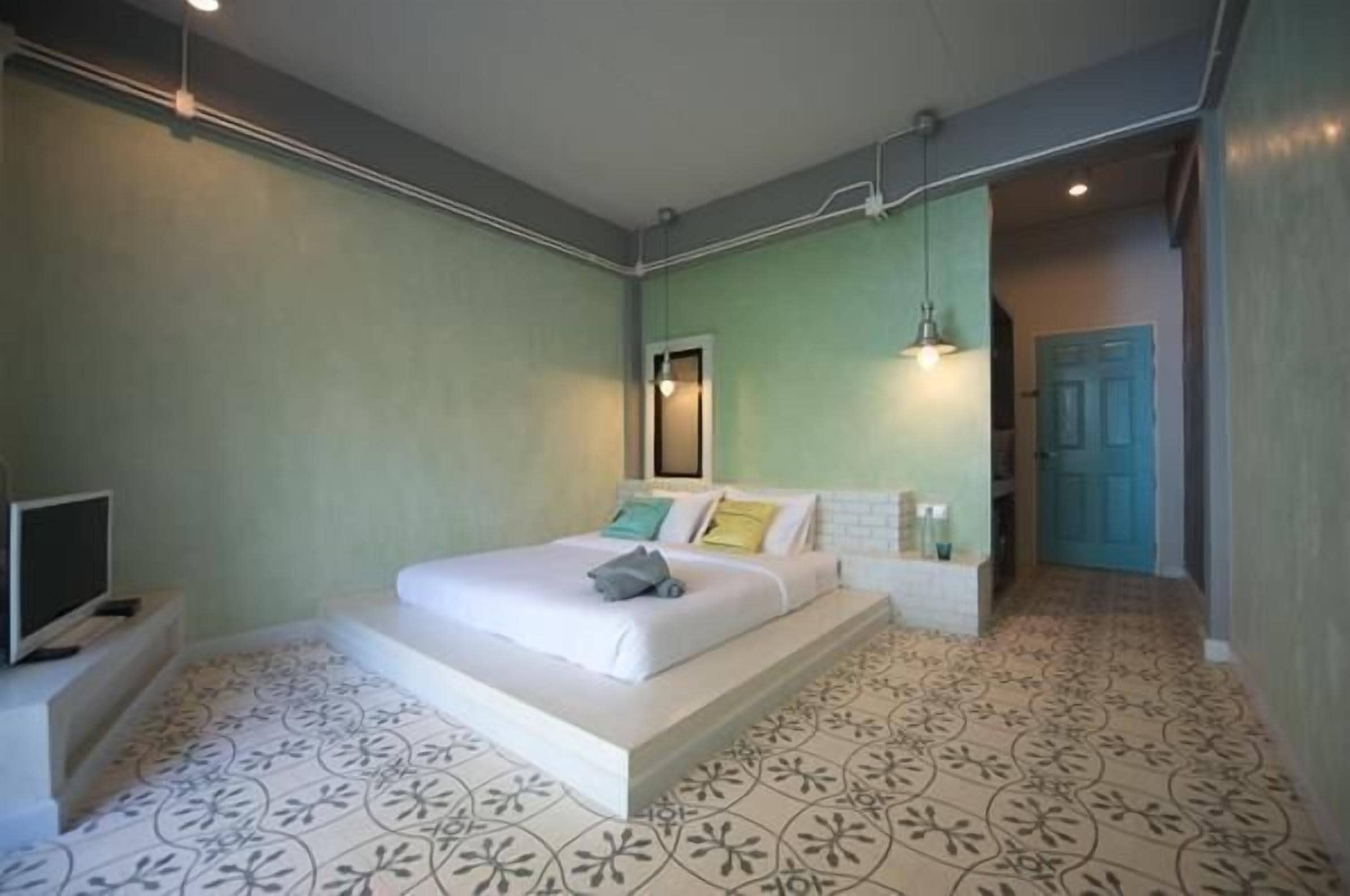 Une chambre à coucher avec un lit, une télévision et un sol à motifs.