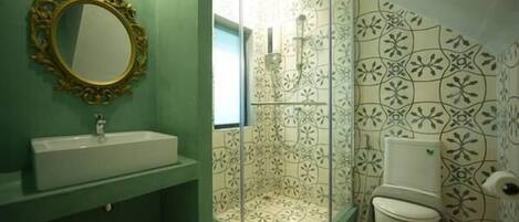 Un baño con lavabo, cabina de ducha e inodoro.