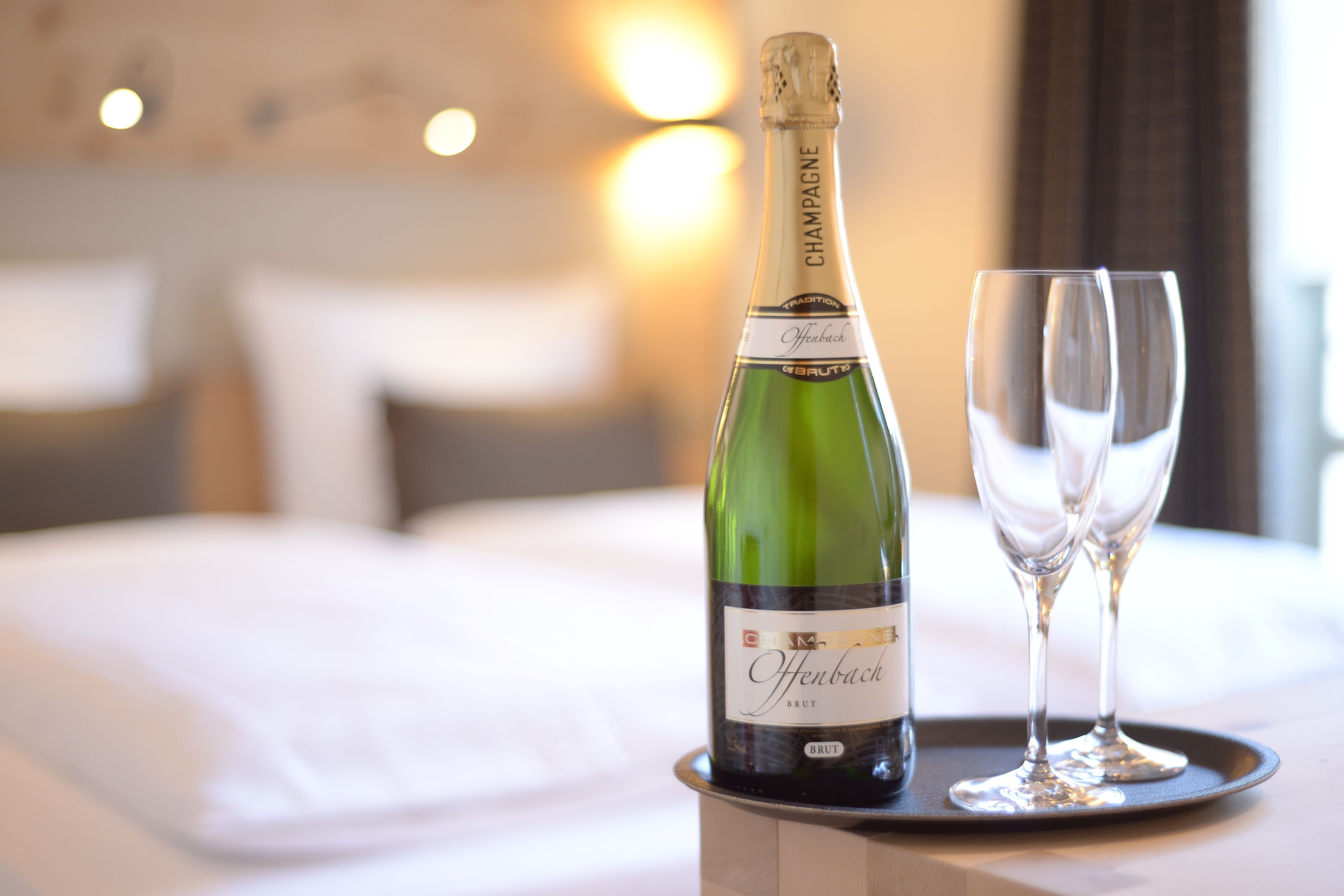 A bottle of champagne and two glasses on a tray.