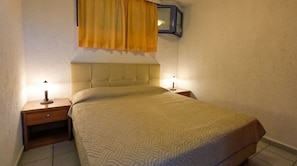 Cama com cabeceira, duas mesas de cabeceira e luminária fixada na parede.