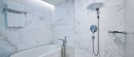 A modern bathroom with a freestanding bathtub, a showerhead, and a towel rack.