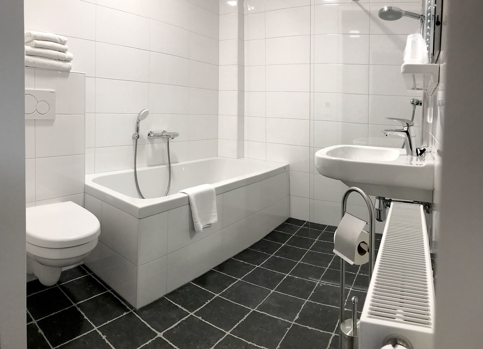 A modern bathroom with a bathtub, toilet, and sink.