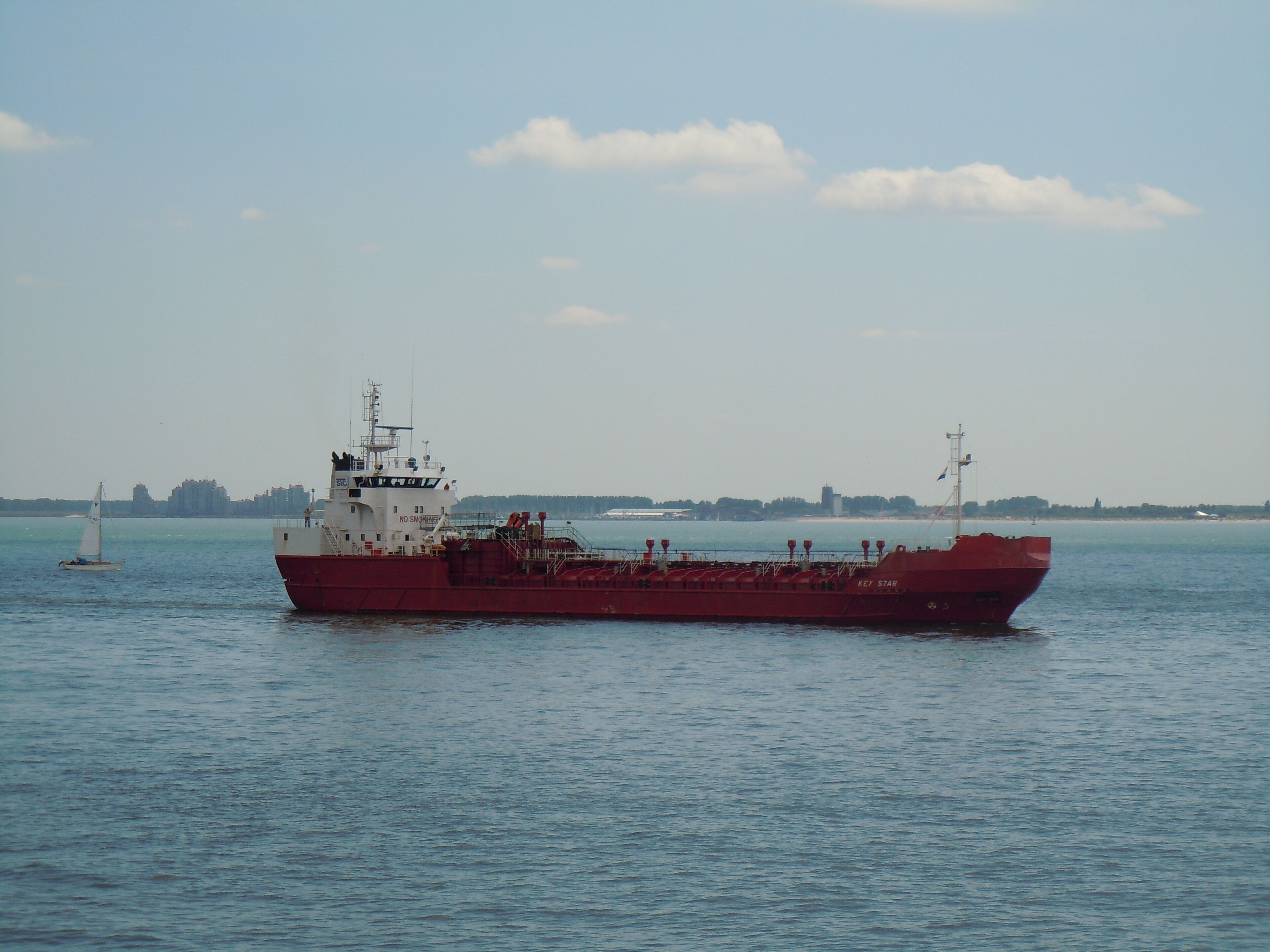 Un gran carguero rojo llamado 'Key Star' en aguas tranquilas.