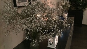 A hallway with a long table displaying a large white flower arrangement. - Hotel De Belgische Loodsensociëteit (Vlissingen)