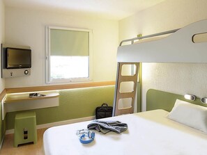 A hotel room with a bunk bed, a desk with a flat-screen TV, a window, and a green wall. - ibis budget Aeroport le Bourget Garonor (Le Blanc-Mesnil)