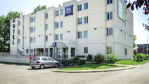 Un hotel de varios pisos con un cartel que indica que es un hotel ibis budget.