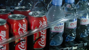 Máquina expendedora con diversas bebidas, incluyendo Coca-Cola, agua Evian, jugo de naranja Minute Maid, té helado Lipton, Sprite y otras opciones.