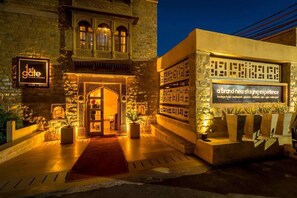 A hotel entrance with a traditional architectural style, featuring a stone facade and arched windows. - 1st Gate Home - Fusion (Jaisalmer)
