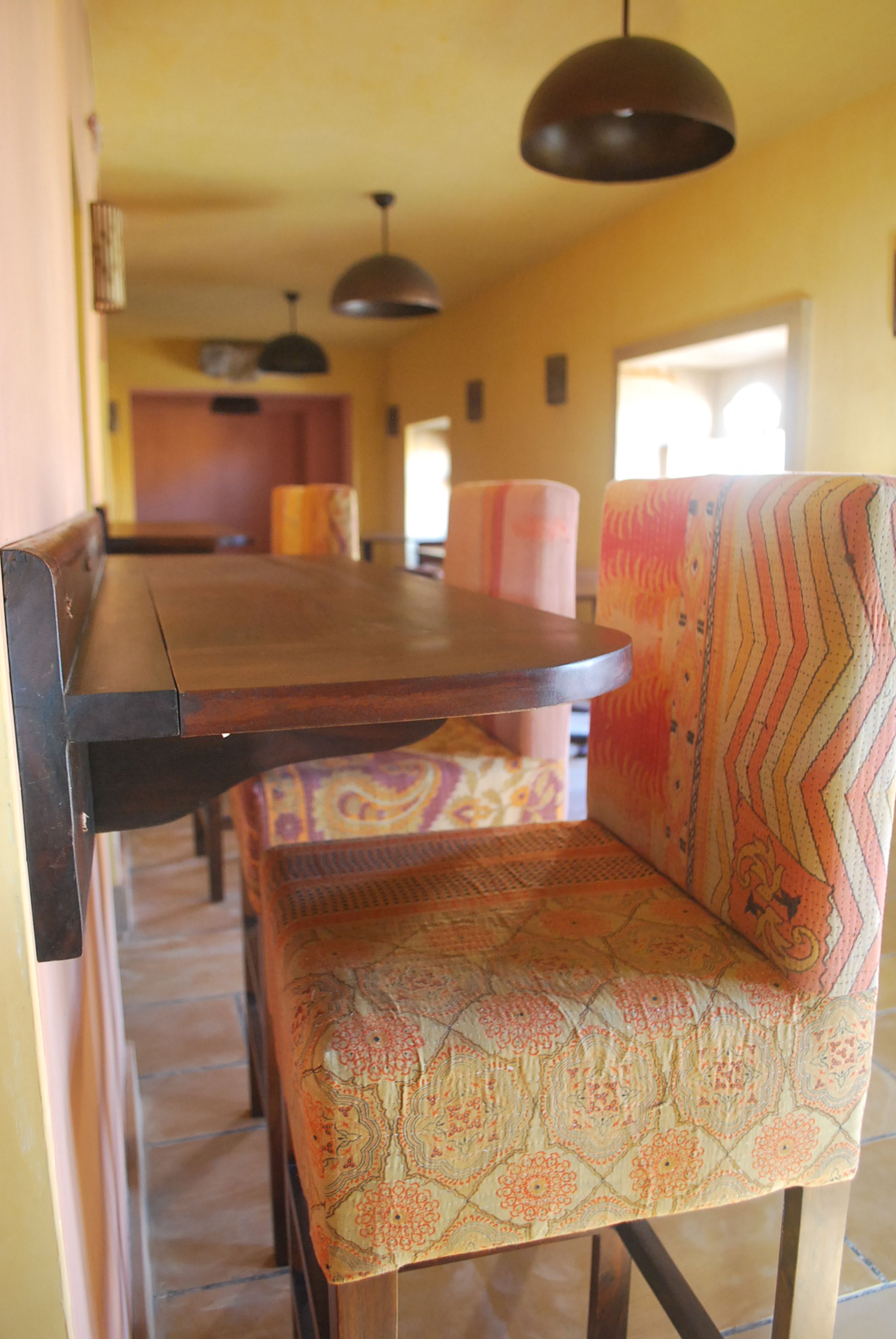 Un coin repas avec une table en bois et des chaises à motifs.