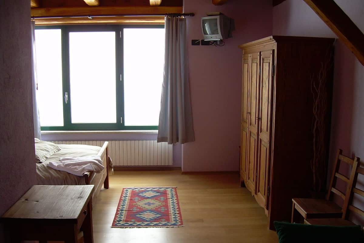 Copriletto in piuma, una scrivania, tende oscuranti