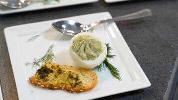 Un plato blanco con una rebanada de pan tostado y un huevo cocido, adornado con hierbas.