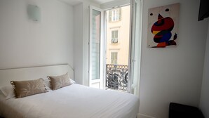 Une chambre à coucher avec un lit, une fenêtre et un balcon.