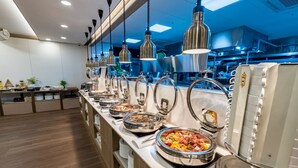 A buffet setup with various food items and utensils. - L&L Central Hotel (Jeju City)
