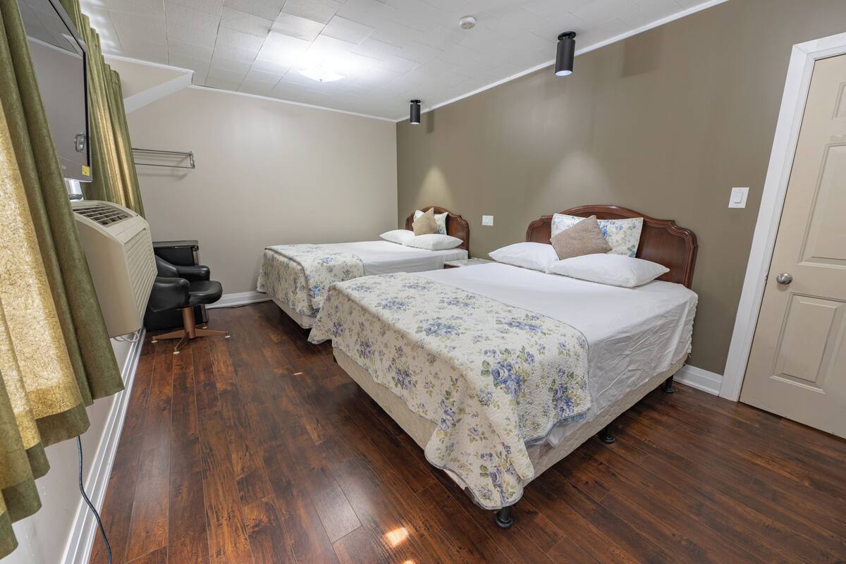 Ein Zimmer mit zwei Betten, einem Sessel und einer Heizung.