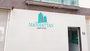 Un edificio con un letrero que dice "Manhattan Apart Hotel" y el número "88" en la puerta.