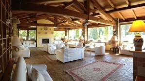 A spacious living area with white furniture, a fireplace, and large windows allowing natural light. - Residenza di Rocca Romana (Sutri)