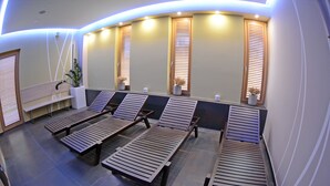 A spa room with wooden loungers, a bench, and potted plants. - Hotel Gallus (Zagreb)