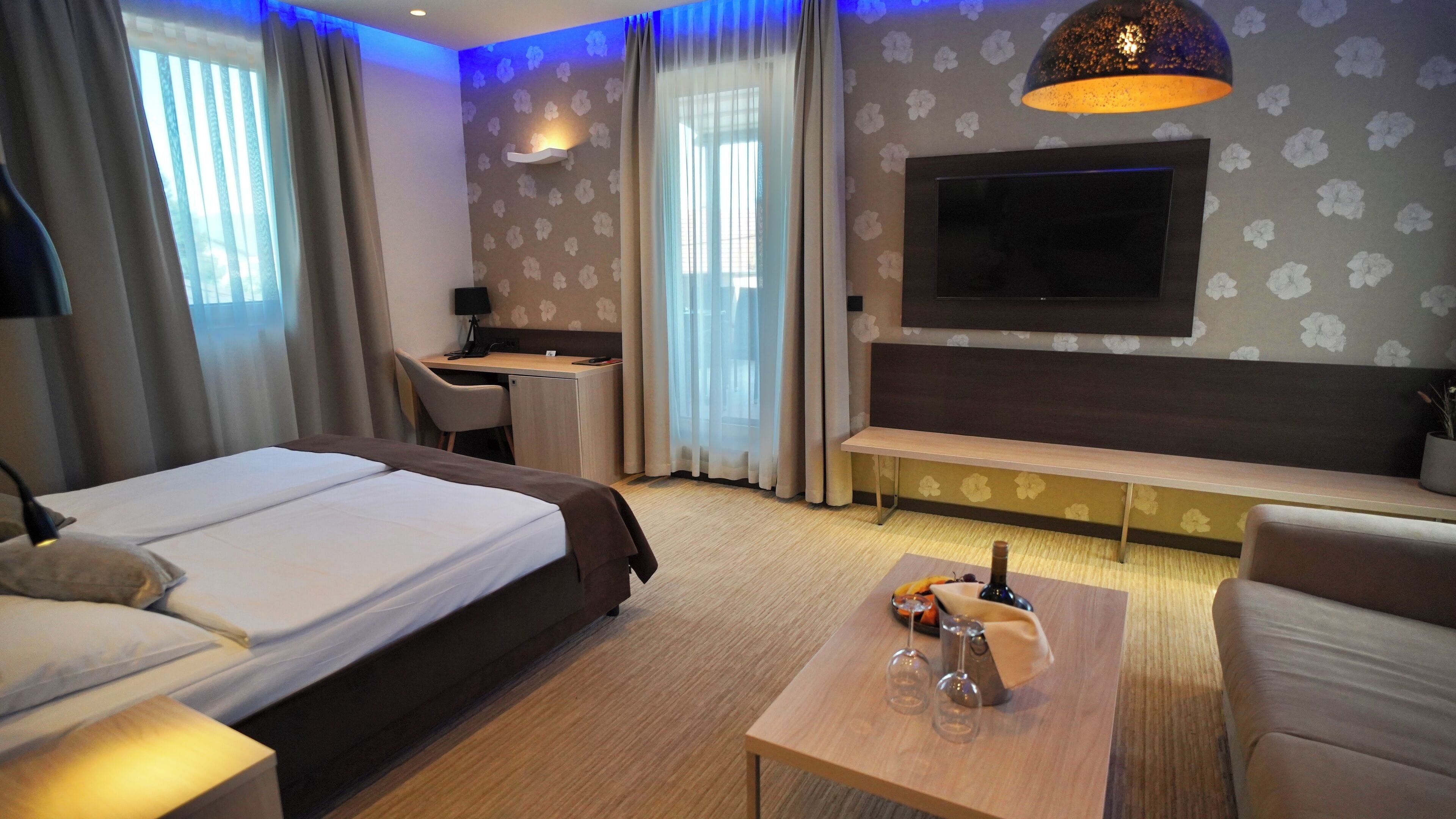 Ein Hotelzimmer mit Bett, Schreibtisch, Fernseher und Sitzgelegenheit.