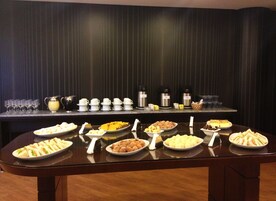 A buffet table with various food items and coffee dispensers.