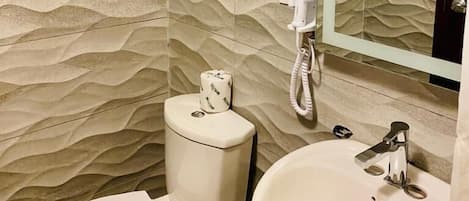 A bathroom with a textured wall, a toilet, a bidet, and a sink.