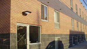 Un edificio de ladrillo con una fila de ventanas y una puerta con reja de metal.