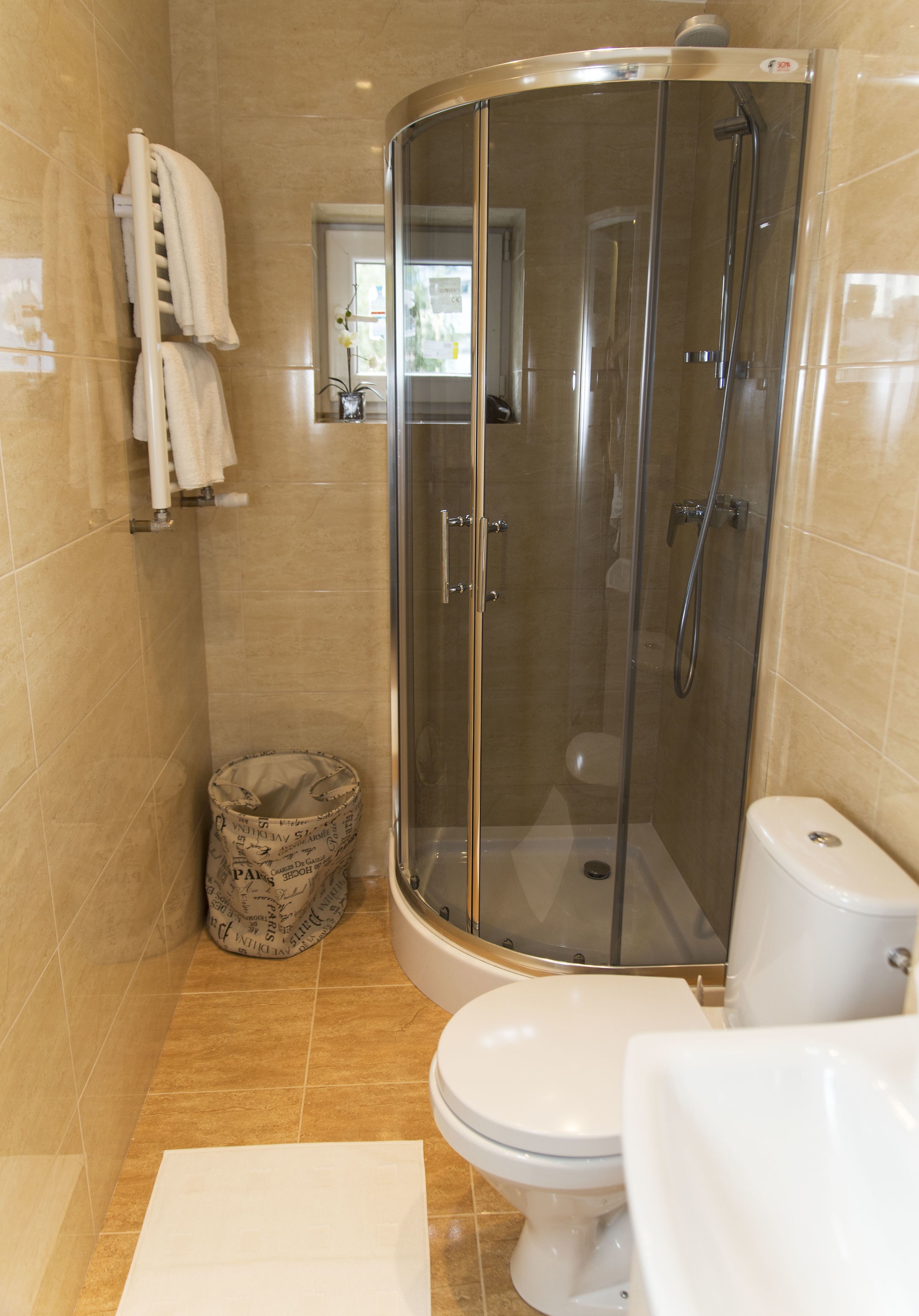 Une salle de bain avec une douche à parois de verre, des toilettes et un lavabo.