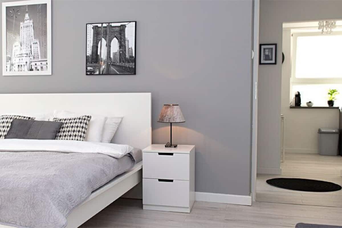 Une chambre à coucher moderne, avec un lit, des tables de chevet et des œuvres d’art murales.