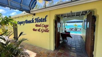 L’entrée de l’hôtel Osprey Beach, avec une enseigne indiquant le « Bird Cage Bar & Grille ».