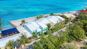 A coastal hotel with multiple buildings, a beach, and clear turquoise waters. - Osprey Beach Hotel (Cockburn Town)