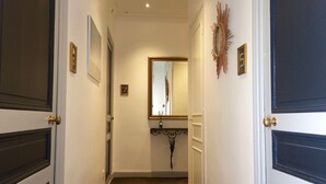 A hallway with dark wooden doors, a mirror, and a number '7' sign. - Hotel Villa Rose (Nice)