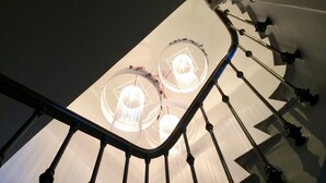 A staircase with a modern design, featuring a metal railing and a ceiling with circular light fixtures. - Hotel Villa Rose (Nice)