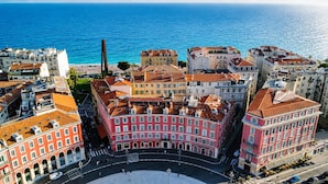 Vista aérea de una ciudad costera con edificios históricos, una rotonda central y una estructura alta destacada.
