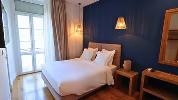 A bedroom with a bed, bedside tables, a lamp, and a mirror.