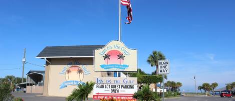 A hotel named 'Inn on the Gulf' with a sign indicating 'Rear Lot Guest Parking Only'.