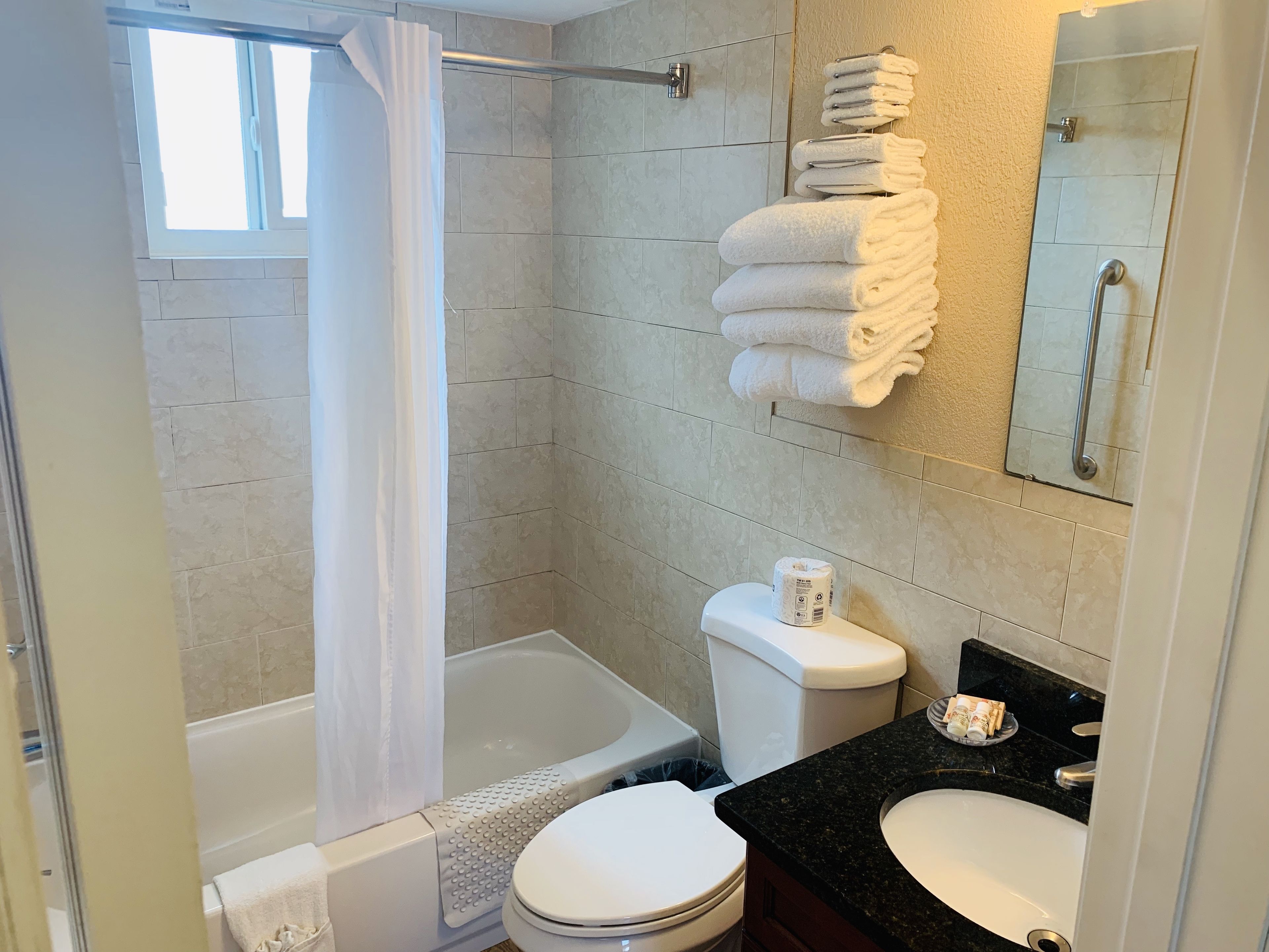 A bathroom with a shower, toilet, and sink.