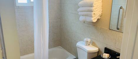 A bathroom with a shower, toilet, and sink.