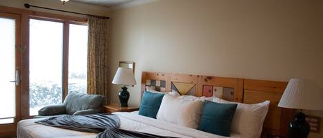 Una camera d'albergo con un letto grande, due comodini, una lampada e vista dalla finestra.