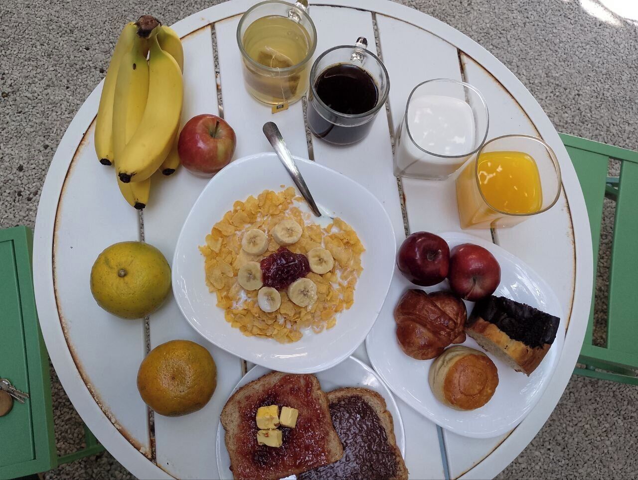 A breakfast table with various food items and drinks.