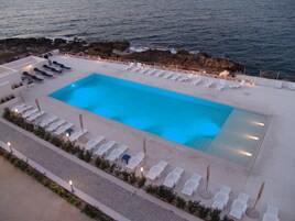 Una piscina al aire libre de temporada, sombrillas