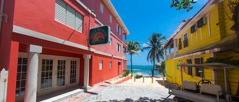 A red building with a sign reading "Mayan Princess" and a yellow building with a golf cart in front.