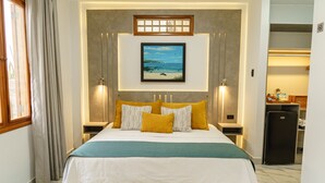 A neatly arranged hotel room with a large bed, a framed picture on the wall, and a small refrigerator in the corner. - Hotel Santa Fe (Puerto Ayora)