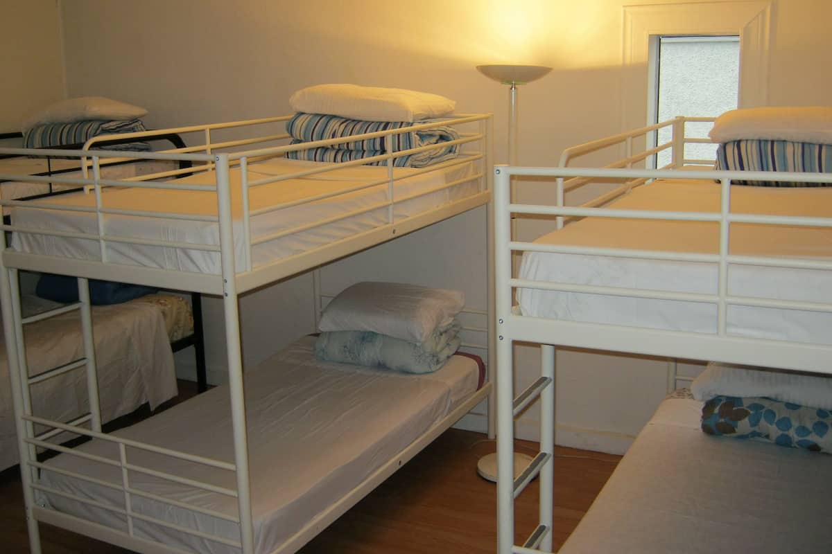 Un dormitorio con literas, una lámpara de pie y una ventana.