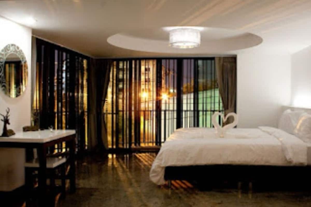 Une chambre à coucher avec un grand lit, un bureau et un miroir.