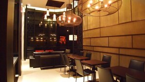 Een modern restaurantinterieur met een bar, zitplaatsen en decoratieve verlichting.