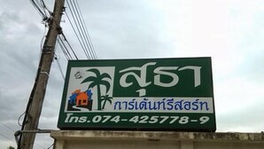 A sign with a house and palm trees, and a phone number.