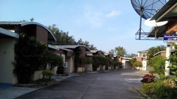 A residential street with houses, satellite dishes, and a clear sky.