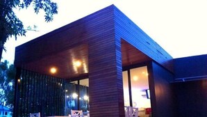 A modern building with a wooden exterior and large glass windows.
